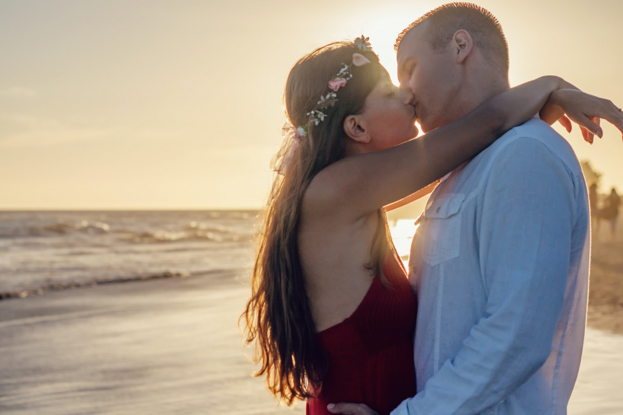 мъж и жена се целуват на плаж